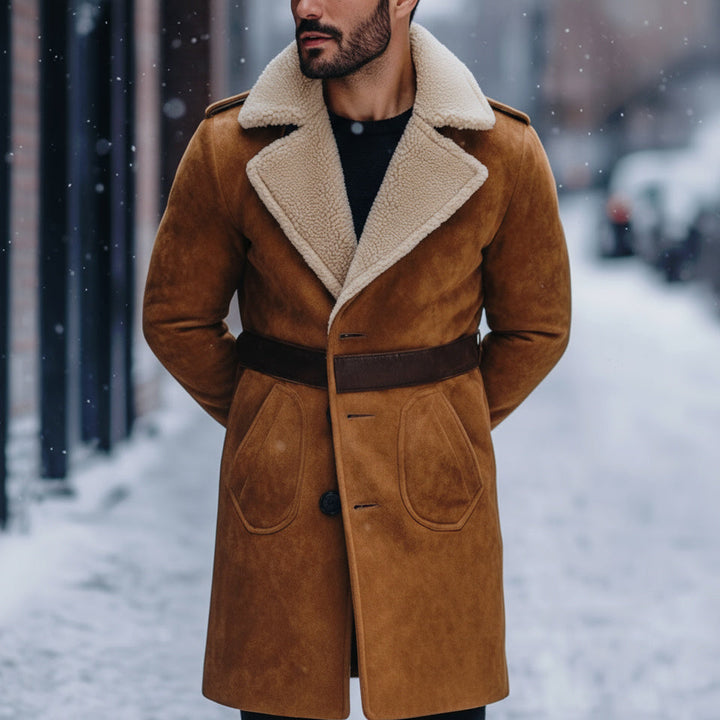 Man wearing a brown suede coat with a fur-lined collar on a snowy street.