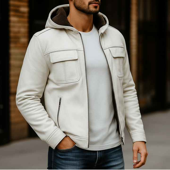 Man wearing a light gray jacket with a hood, white shirt, and jeans in an urban setting.